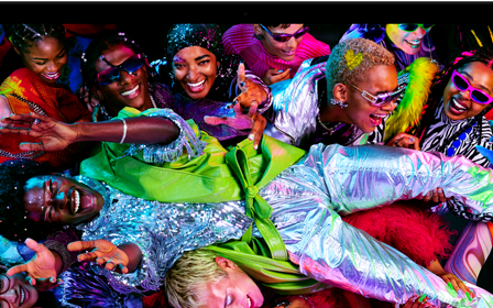 Lo splendido display Liquid Retina XDR di un MacBook Pro che mostra una schermata colorata con una persona che fa surf sulla folla a una festa