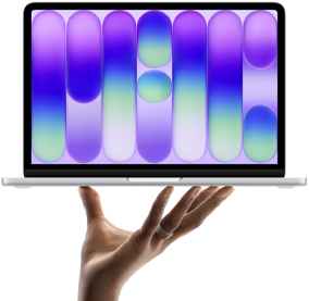 MacBook Neo color argento in equilibrio sulla punta delle dita di una mano aperta, lo schermo mostra un motivo astratto colorato